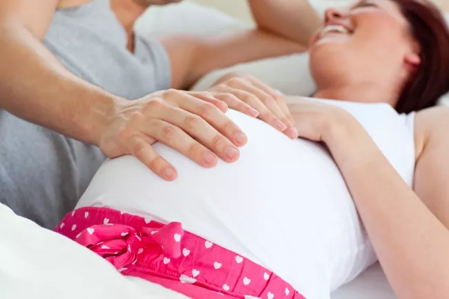 Pregnant mom lying down next to her partner