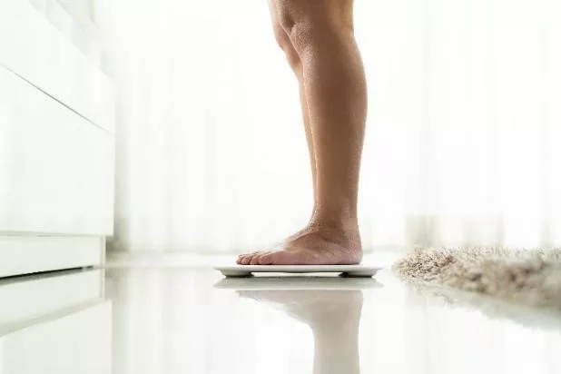 Pregnant mom standing on the weighing scale