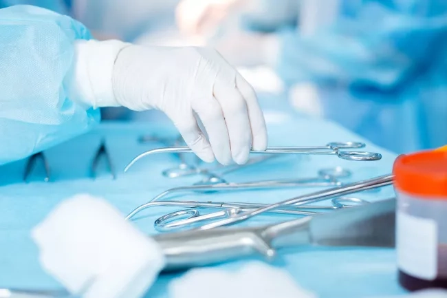 Surgeon holding medical instruments 